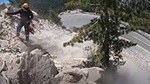 A Caltrans worker on a "scaling crew" rappels down a mountain face and knocks boulders down to the closed road below as part of a proactive Maintenance program that protects motorists traveling on rockfall-prone state highways.